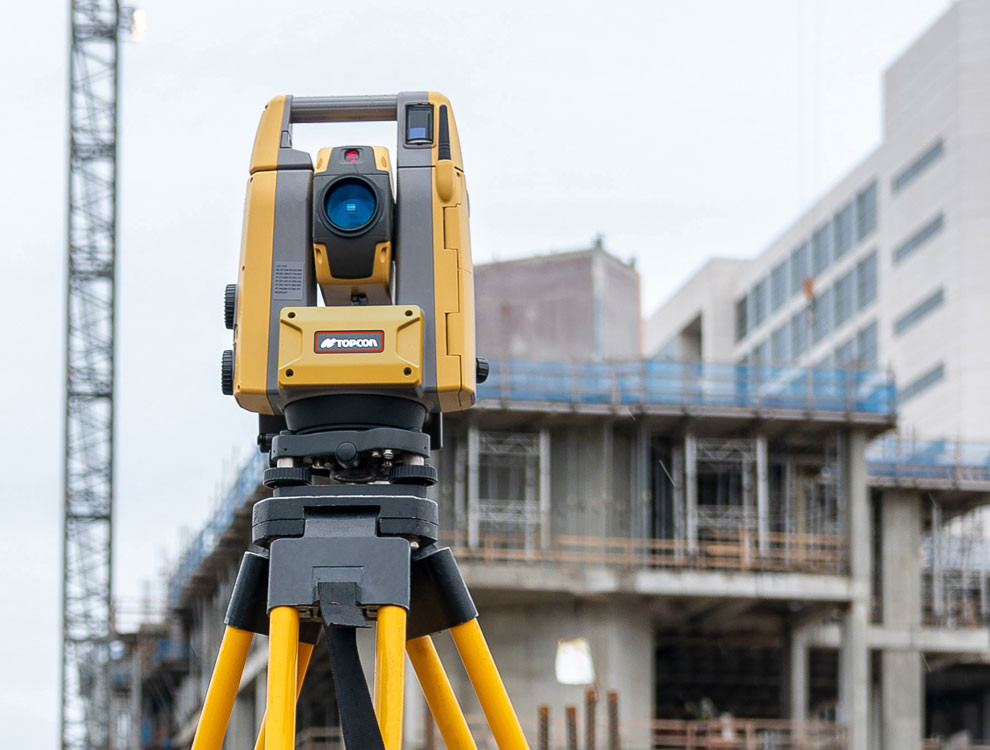 Surveying team conducting field measurements with modern equipment